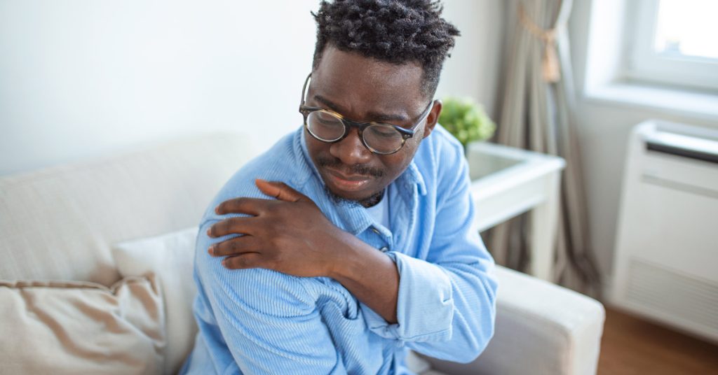 African male exhibiting shoulder pain.