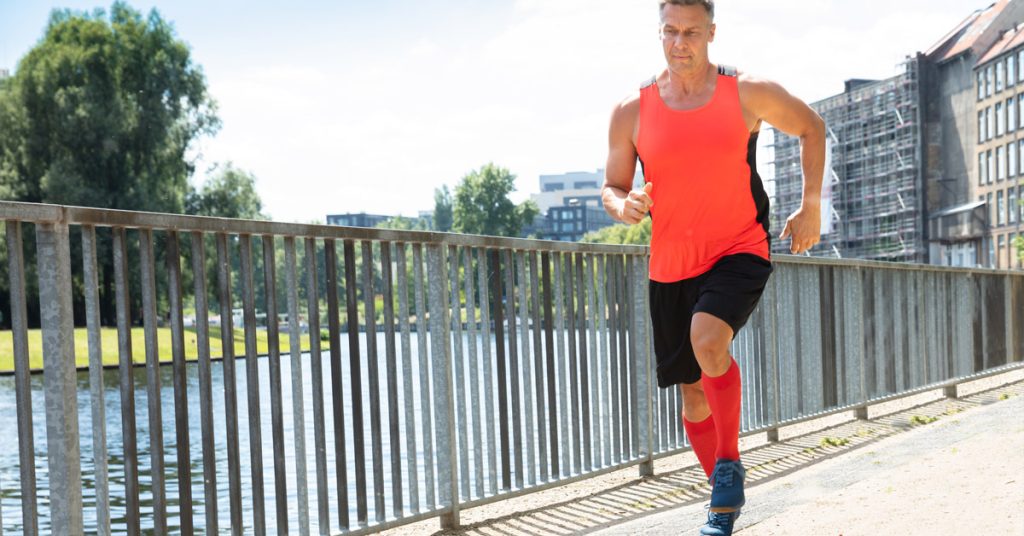 Man jogging wearing compression socks.